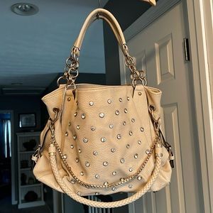 Shi, ivory tote bag with rhinestones on the front and gold hardware.